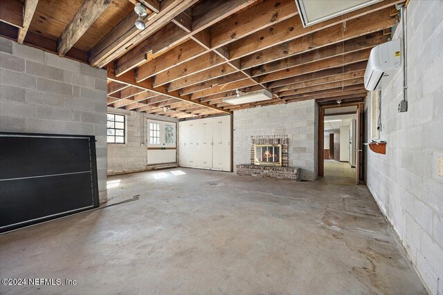 basement with a wall unit AC and a fireplace