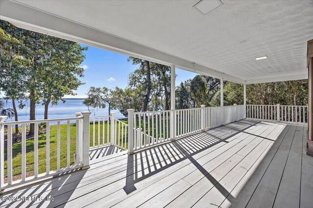 wooden deck with a yard and a water view