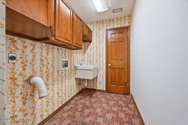 clothes washing area with hookup for an electric dryer, sink, cabinets, and washer hookup