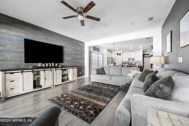 living room featuring light wood-type flooring and ceiling fan