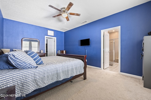 bedroom featuring connected bathroom, a textured ceiling, light colored carpet, and ceiling fan