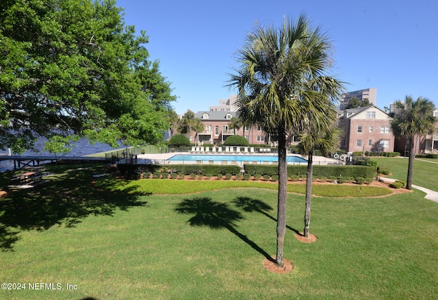 view of home's community featuring a lawn and a pool