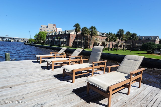 dock area with a water view and a yard