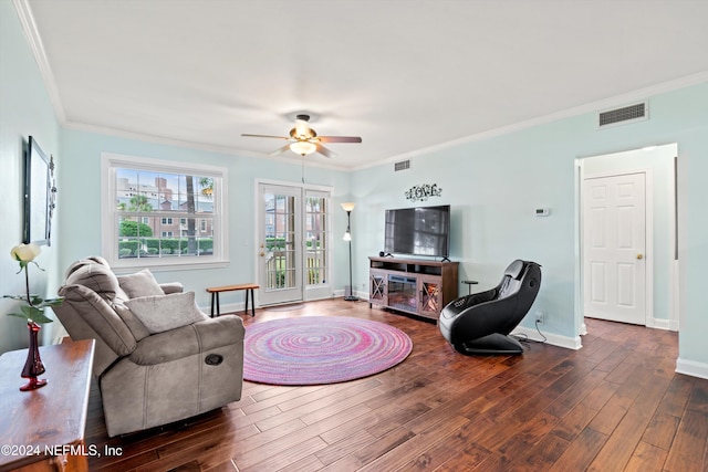 living room featuring dark wood-type flooring, ceiling fan, and crown molding