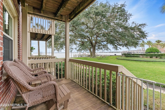 deck with a yard and a water view