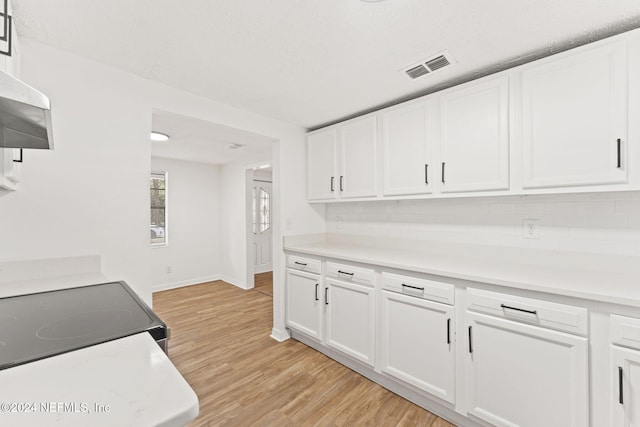 kitchen featuring light hardwood / wood-style floors, range, decorative backsplash, and white cabinets