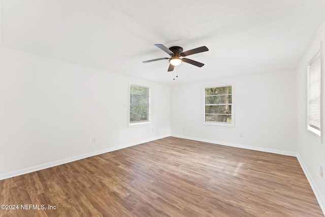 spare room with hardwood / wood-style floors, a textured ceiling, and ceiling fan