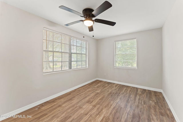 unfurnished room with hardwood / wood-style floors, a healthy amount of sunlight, and ceiling fan