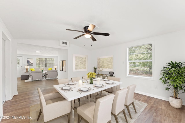 dining room with lofted ceiling, hardwood / wood-style flooring, and ceiling fan