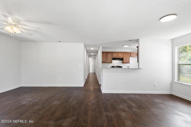 unfurnished living room with a textured ceiling, ceiling fan, and dark hardwood / wood-style flooring