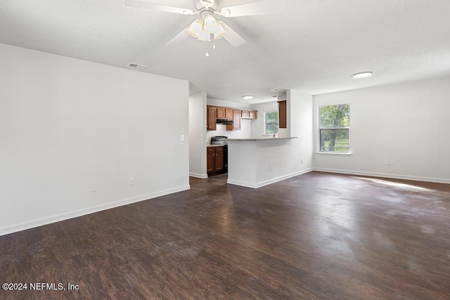 unfurnished living room with a textured ceiling, dark hardwood / wood-style floors, and ceiling fan