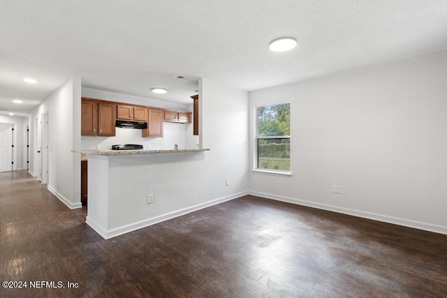 kitchen featuring kitchen peninsula, dark hardwood / wood-style floors, and black range oven