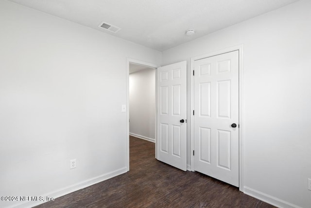 unfurnished bedroom featuring dark hardwood / wood-style flooring