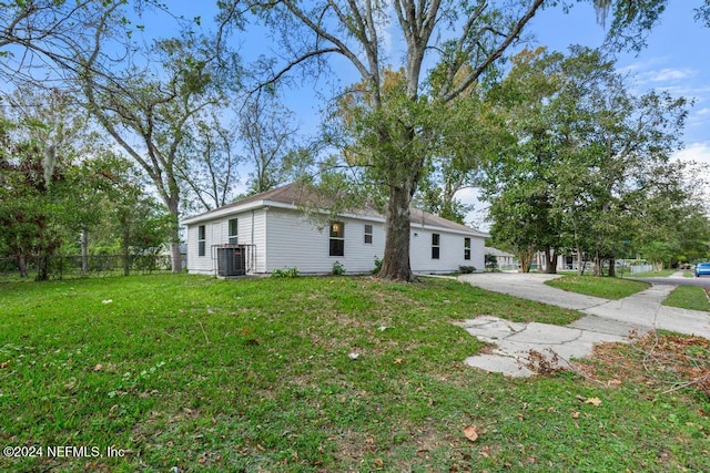 exterior space with central AC and a lawn