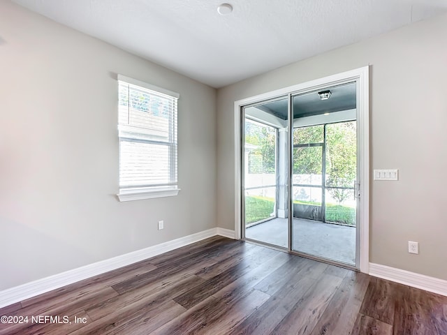 unfurnished room with dark hardwood / wood-style floors and a textured ceiling