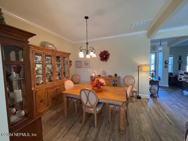 dining space featuring a notable chandelier, ornamental molding, and dark hardwood / wood-style floors