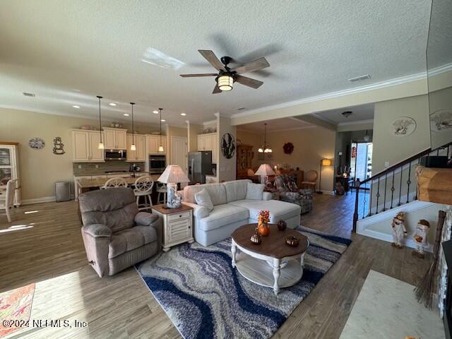 211 Dolcetto Dr, Saint Augustine, FL 32092 - living area with ornamental molding, light wood-style floors, a ceiling fan, baseboards, and stairs