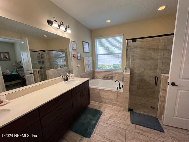 bathroom with vanity, independent shower and bath, and tile patterned floors