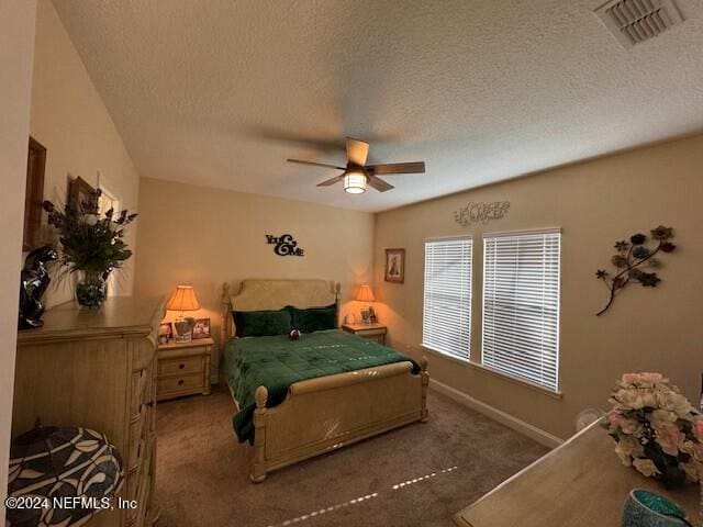 carpeted bedroom featuring a textured ceiling and ceiling fan