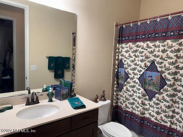 bathroom featuring vanity, toilet, and a shower with shower curtain