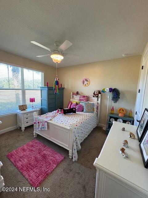 bedroom with dark colored carpet and ceiling fan