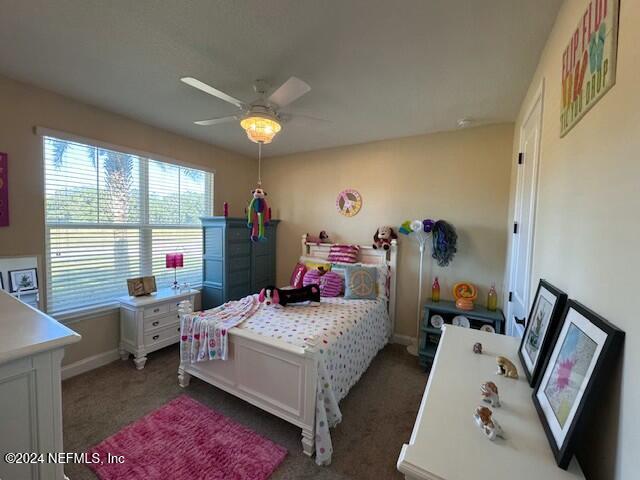 bedroom featuring ceiling fan and dark colored carpet