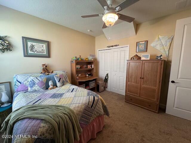 carpeted bedroom featuring a closet and ceiling fan