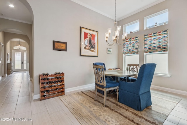 dining area with tile patterned flooring, a healthy amount of sunlight, an inviting chandelier, and ornamental molding