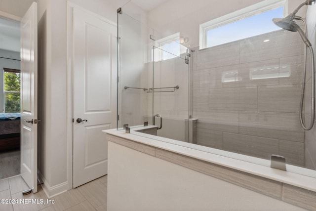 bathroom with a shower with door and a healthy amount of sunlight