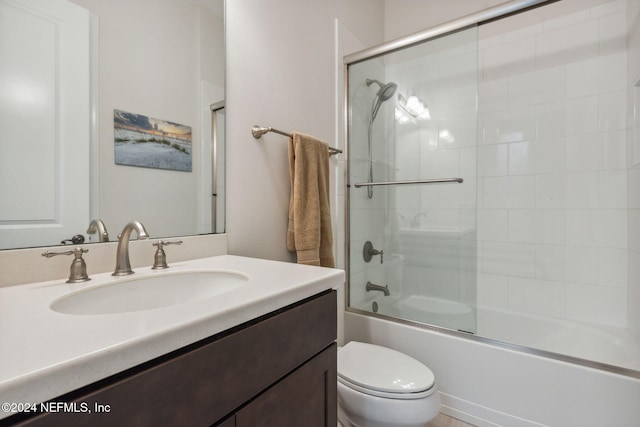 full bathroom with bath / shower combo with glass door, vanity, and toilet