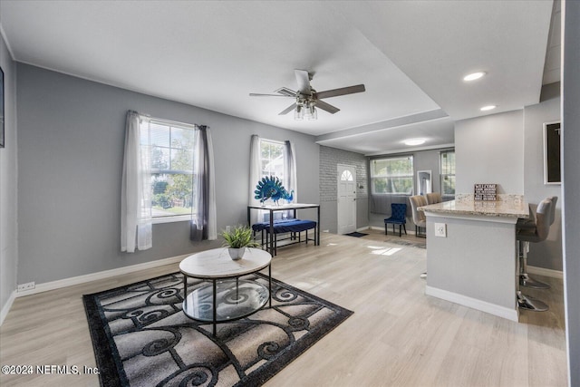 living room with light hardwood / wood-style flooring, ceiling fan, and plenty of natural light