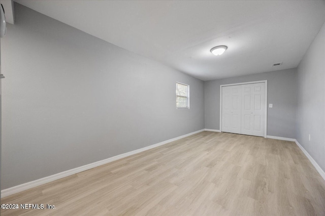 unfurnished bedroom featuring light hardwood / wood-style floors and a closet