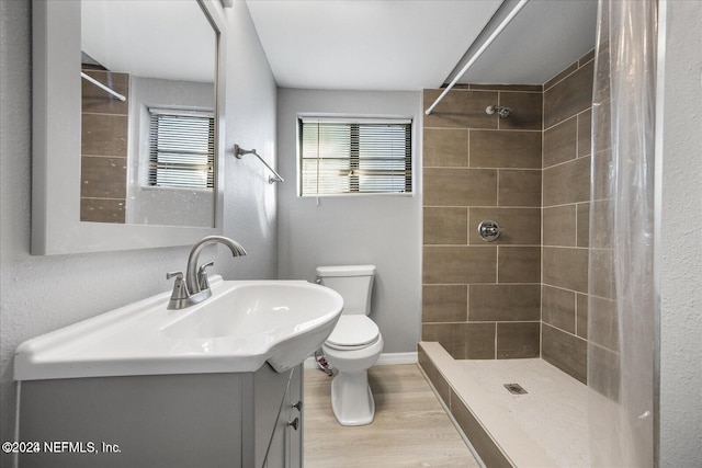 bathroom with toilet, a shower with curtain, vanity, and hardwood / wood-style flooring