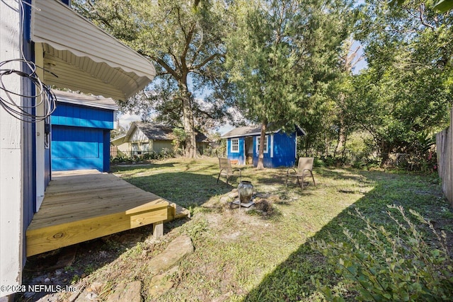 view of yard featuring a wooden deck and an outdoor structure