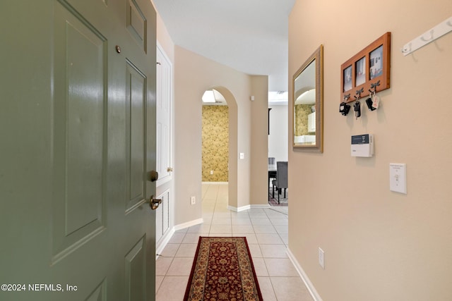 7801 Point Meadows Dr Unit 8406, Jacksonville, FL 32256 - hallway featuring arched walkways, baseboards, and light tile patterned floors