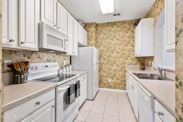 7801 Point Meadows Dr Unit 8406, Jacksonville, FL 32256 - kitchen featuring light tile patterned floors, white appliances, visible vents, a sink, and white cabinets