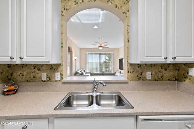 7801 Point Meadows Dr Unit 8406, Jacksonville, FL 32256 - kitchen featuring a sink, dishwasher, light countertops, arched walkways, and white cabinets