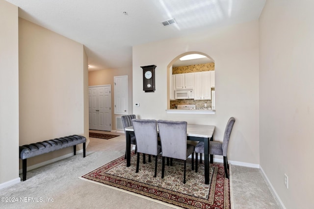 7801 Point Meadows Dr Unit 8406, Jacksonville, FL 32256 - dining room with baseboards, light carpet, visible vents, and arched walkways