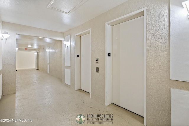 7801 Point Meadows Dr Unit 8406, Jacksonville, FL 32256 - hall with elevator, concrete flooring, and a textured wall