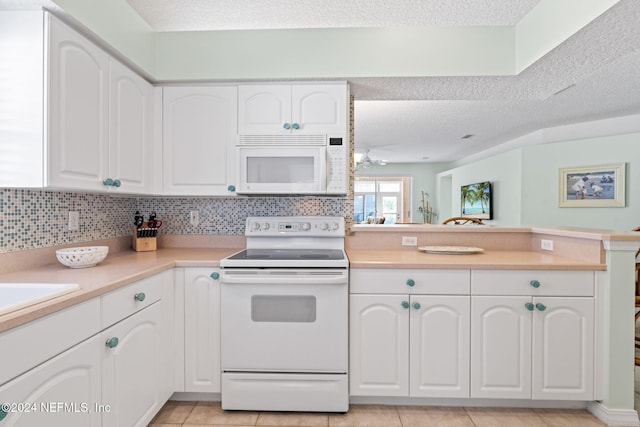 193 Lions Gate Dr, Saint Augustine, FL 32080 - kitchen with white appliances, a textured ceiling, a peninsula, white cabinets, and light countertops