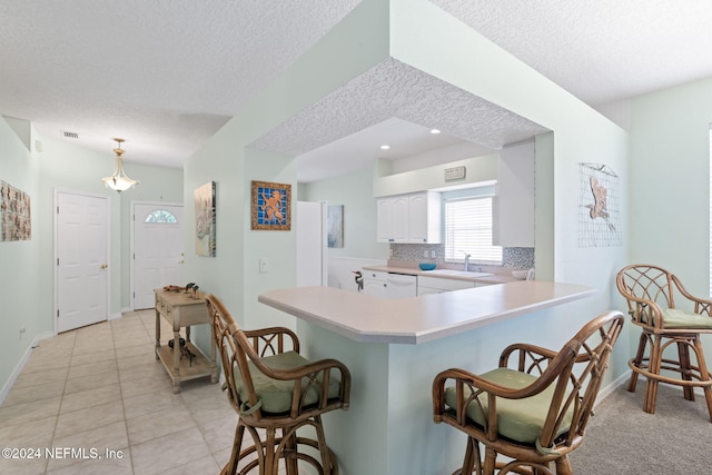193 Lions Gate Dr, Saint Augustine, FL 32080 - kitchen with a sink, a textured ceiling, a kitchen bar, light countertops, and dishwasher
