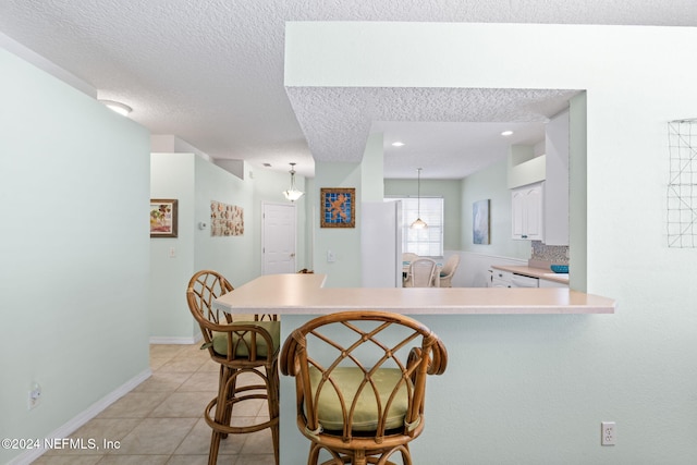 193 Lions Gate Dr, Saint Augustine, FL 32080 - kitchen with a peninsula, light countertops, white cabinetry, light tile patterned floors, and a breakfast bar