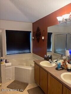 bathroom with tile patterned floors, vanity, and tiled bath