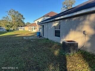 view of side of home with cooling unit and a lawn