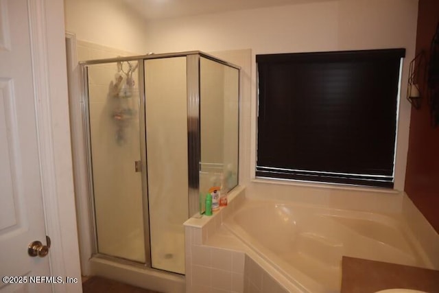 bathroom with a stall shower and a bath