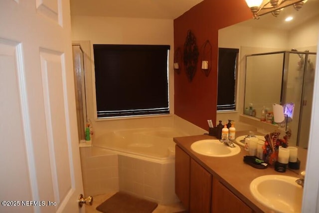 full bath with a bath, a stall shower, double vanity, and a sink