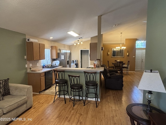 694 Cherry Bark Dr N, Jacksonville, FL 32218 - kitchen featuring a breakfast bar, black dishwasher, stainless steel fridge, a chandelier, and a sink