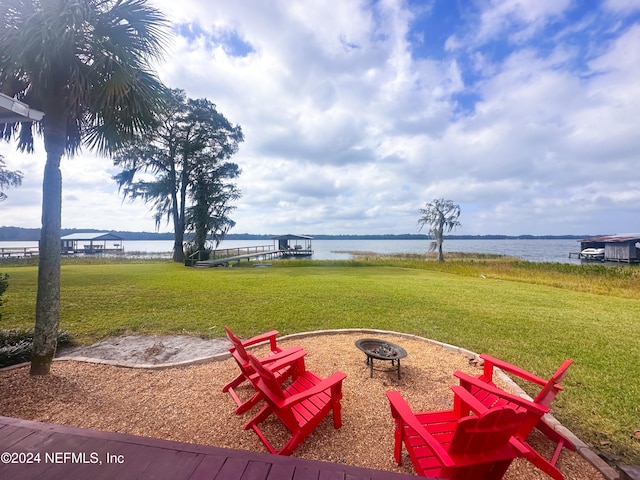 view of yard with an outdoor fire pit and a water view