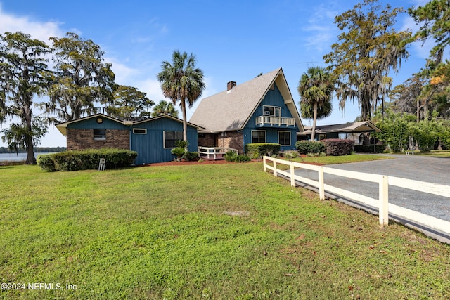 view of front of property featuring a front lawn and a balcony