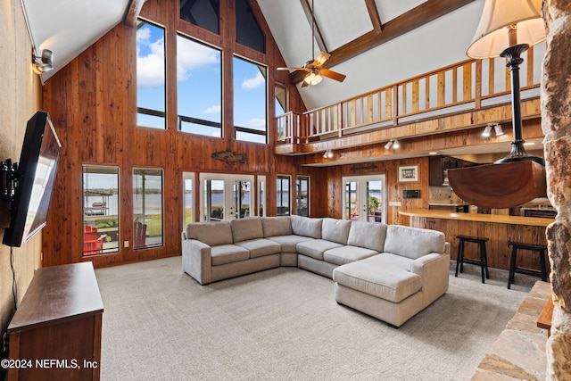 carpeted living room featuring french doors, high vaulted ceiling, beamed ceiling, and ceiling fan